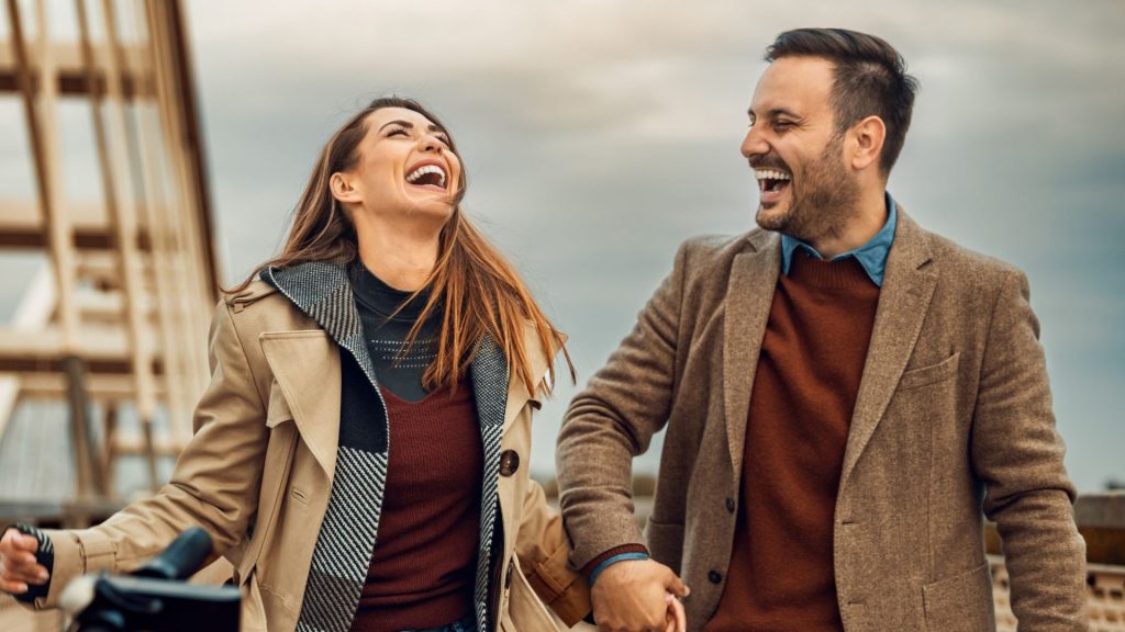 Woman and man on a date holding hands and laughing